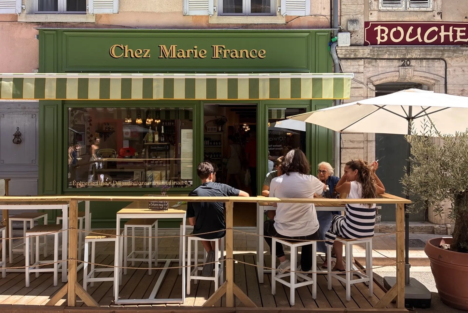 Façade verte et terrasse de Chez Marie France, épicerie fine à Cluny, rue Mercière